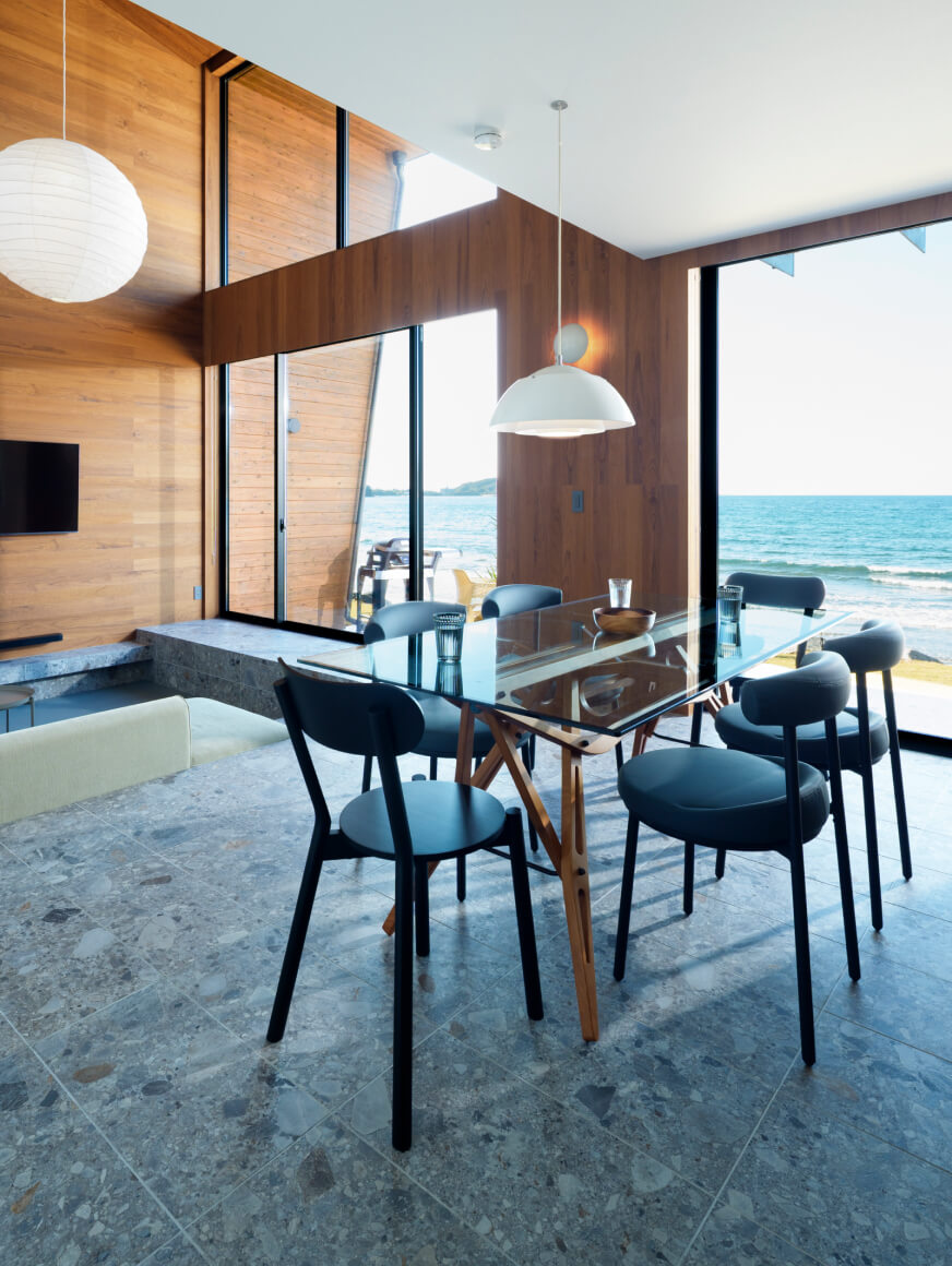 室内に駐輪したバイク越しに海を眺める